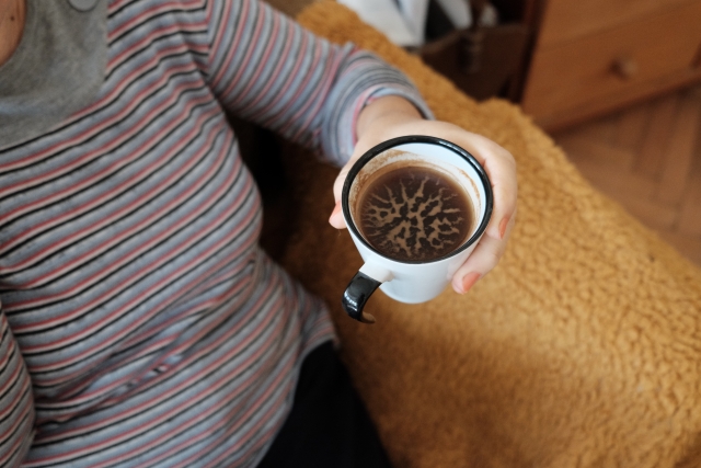 ソファーの上でコーヒーを飲む