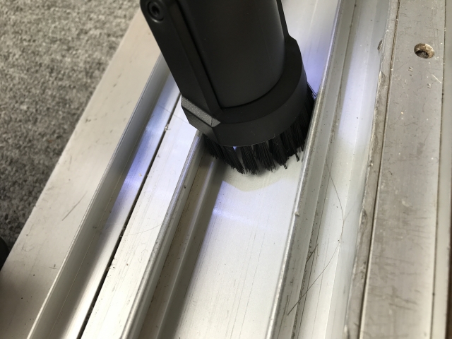 サッシのごみを掃除機で吸い取る