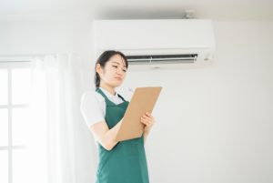 エアコンの下で悩む人