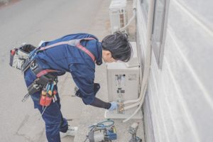室外機をチェックするスタッフ 