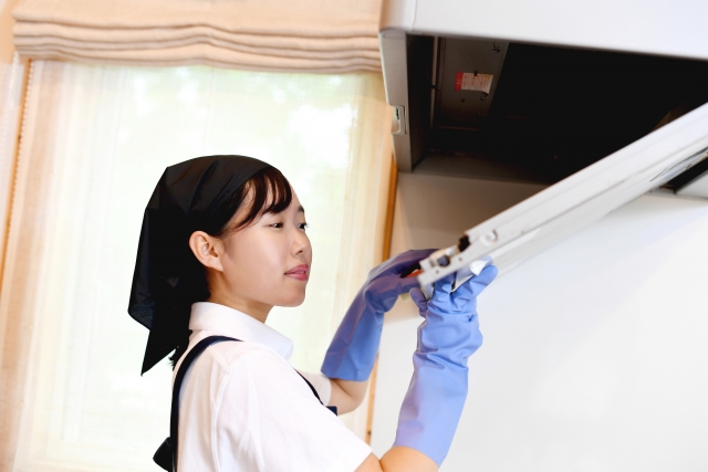換気扇を取り外す女性