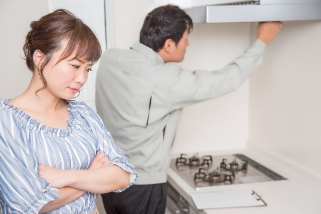 換気扇点検業者と悩む女性